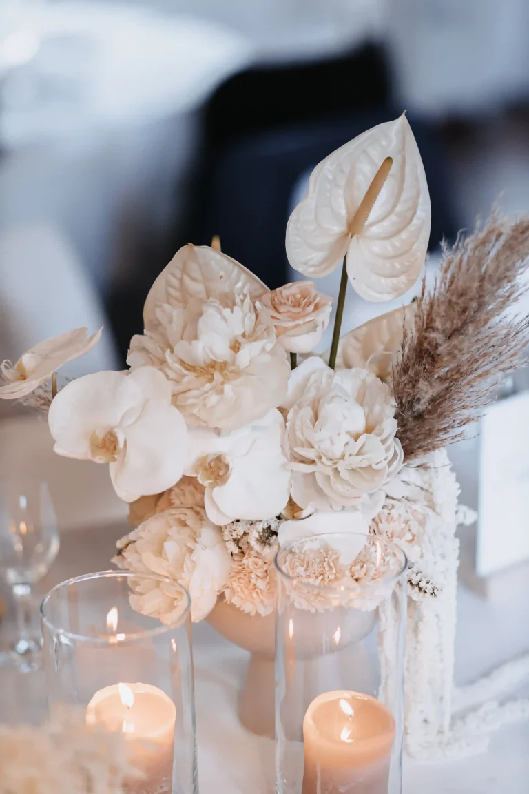 klassische Tischdeko mit Blumen, Kerzen in transparenten Vasen auf einer Hochzeit